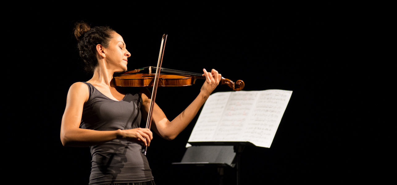 Andrea Tyniec performing on stage with violin
