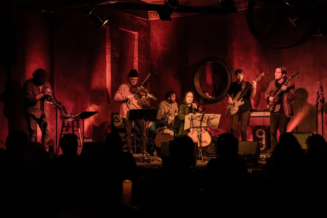 SICK BOSS performing on stage, bathed in a red light