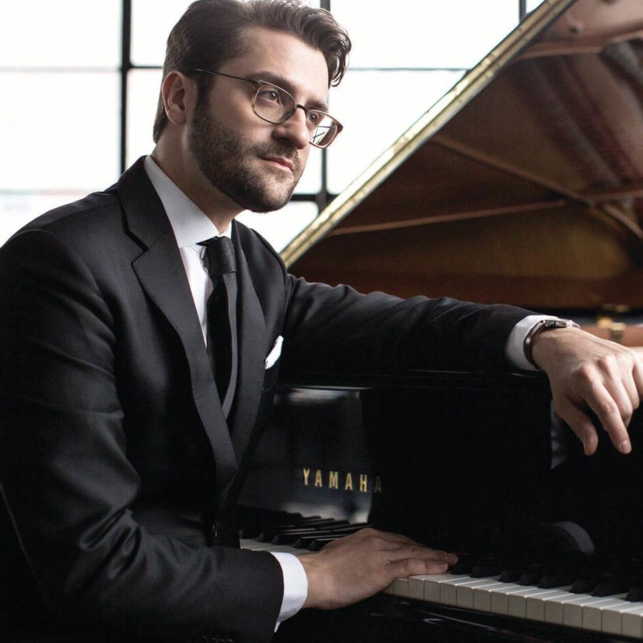 David Kaplan sitting in front of a Yamaha piano