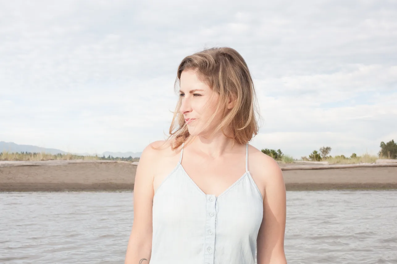 Leah in a white dress looking to the side