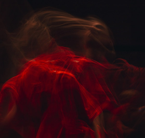 A time-lapsed photo of Vanessa Goodman in a red light