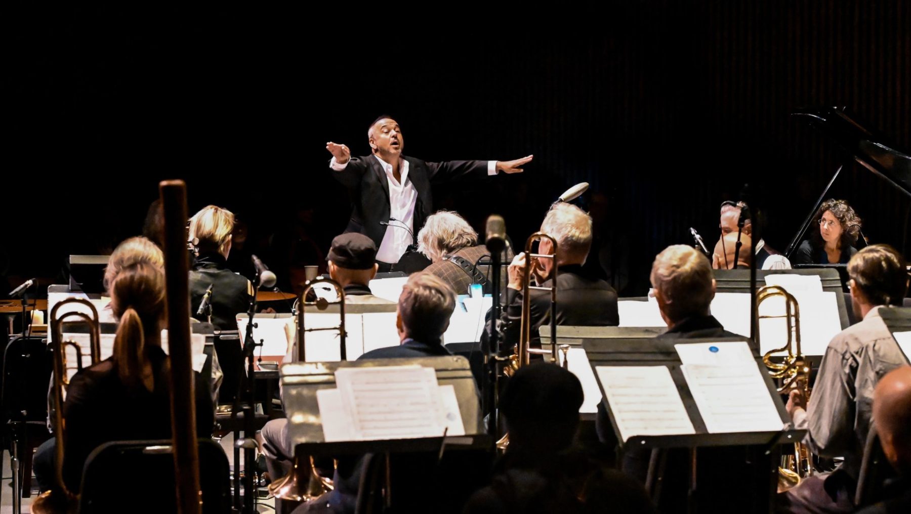 John Korsrud in the back conducting an orchestra