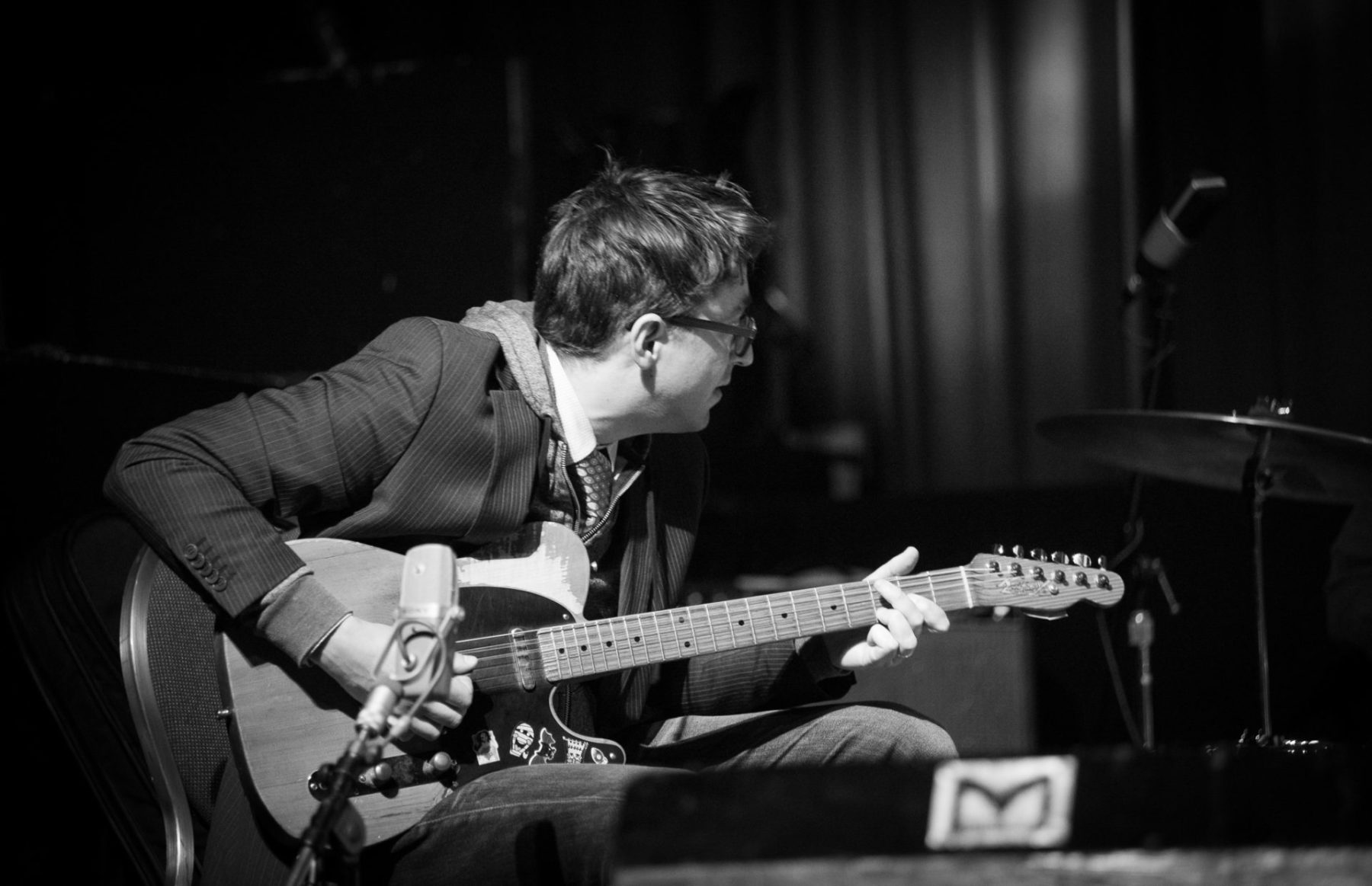 Blakc and white, Aram Bajakian playing the guitar and looking off to the side