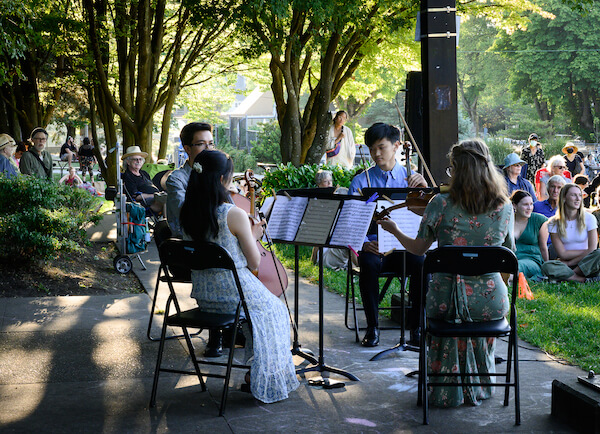 Cedar Quartet performing in the park, with Mio and Norah with their backs to the camera