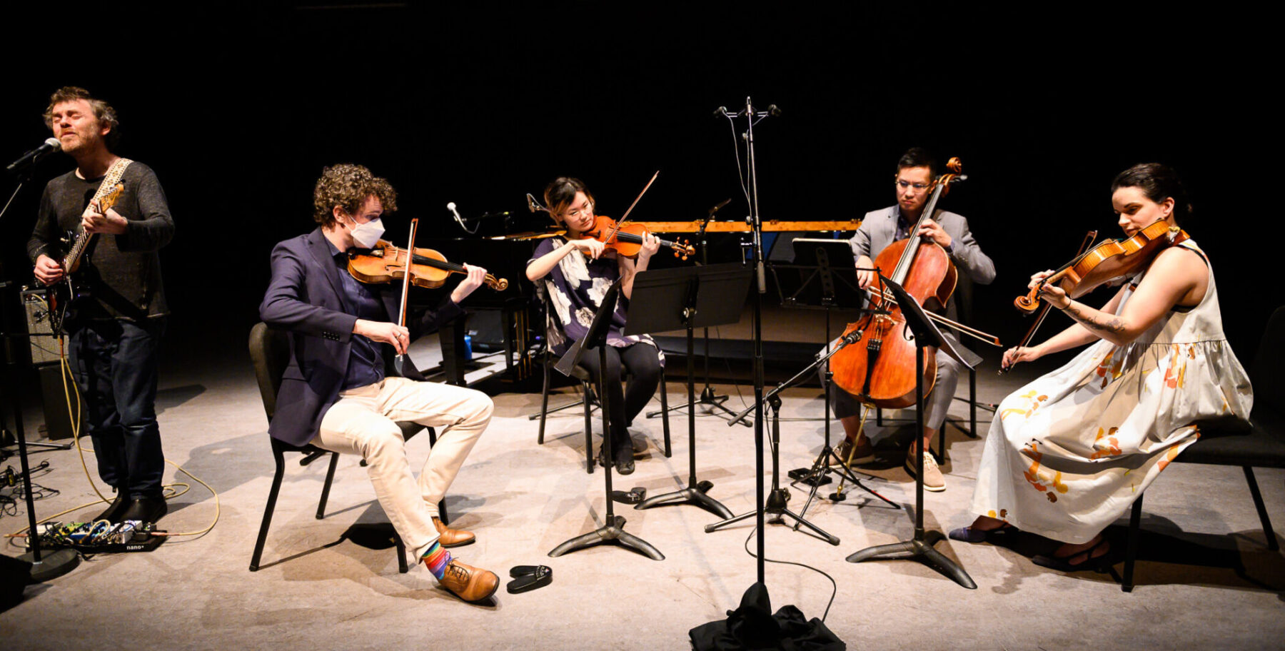Gabriel Kahane playing guitar on the left with the Capilano String Quartet on the right