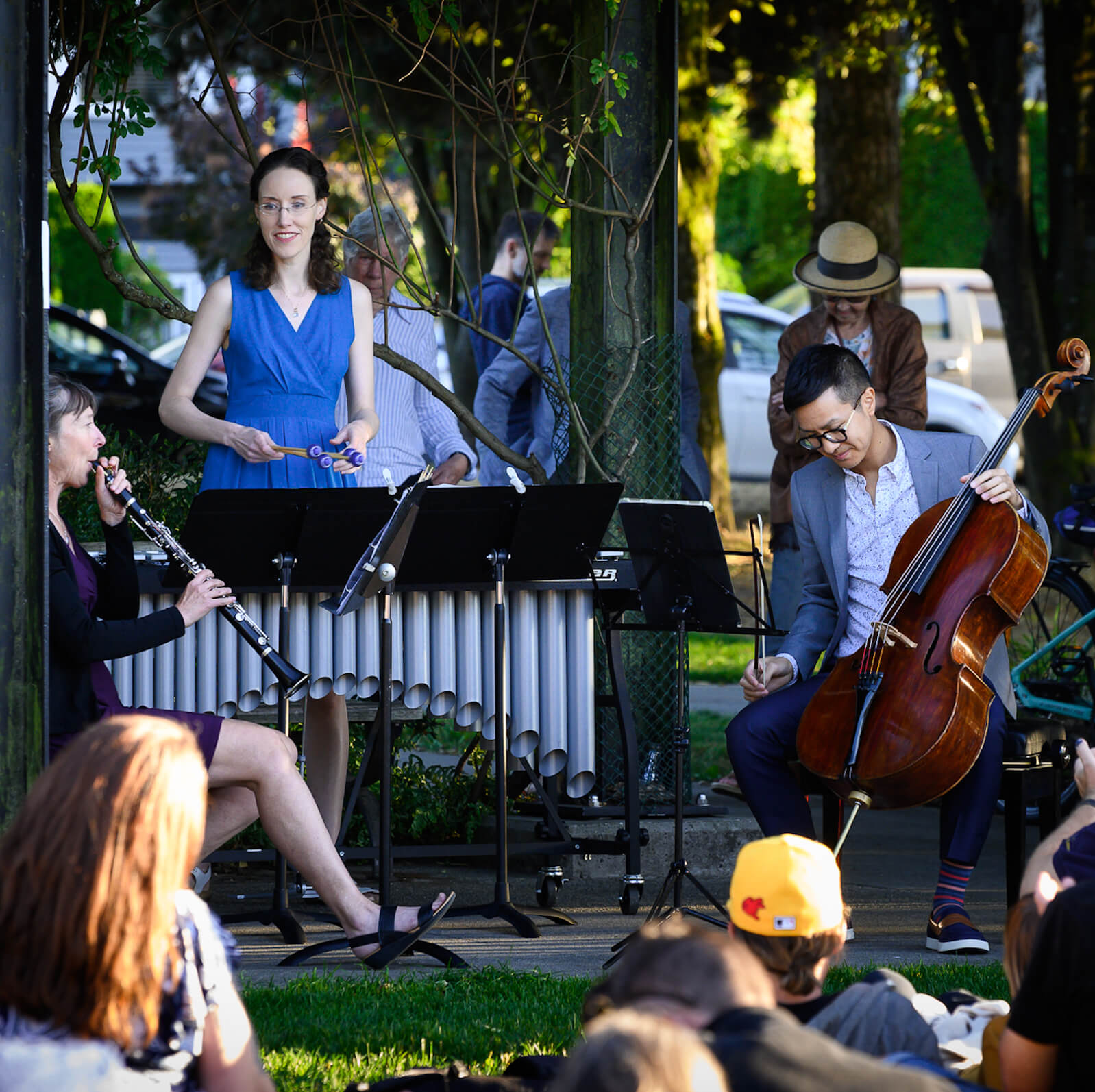 Nicola Everton on clarinet, Katie Rife on vibraphone, and Jonathan Lo on cello playing in the park