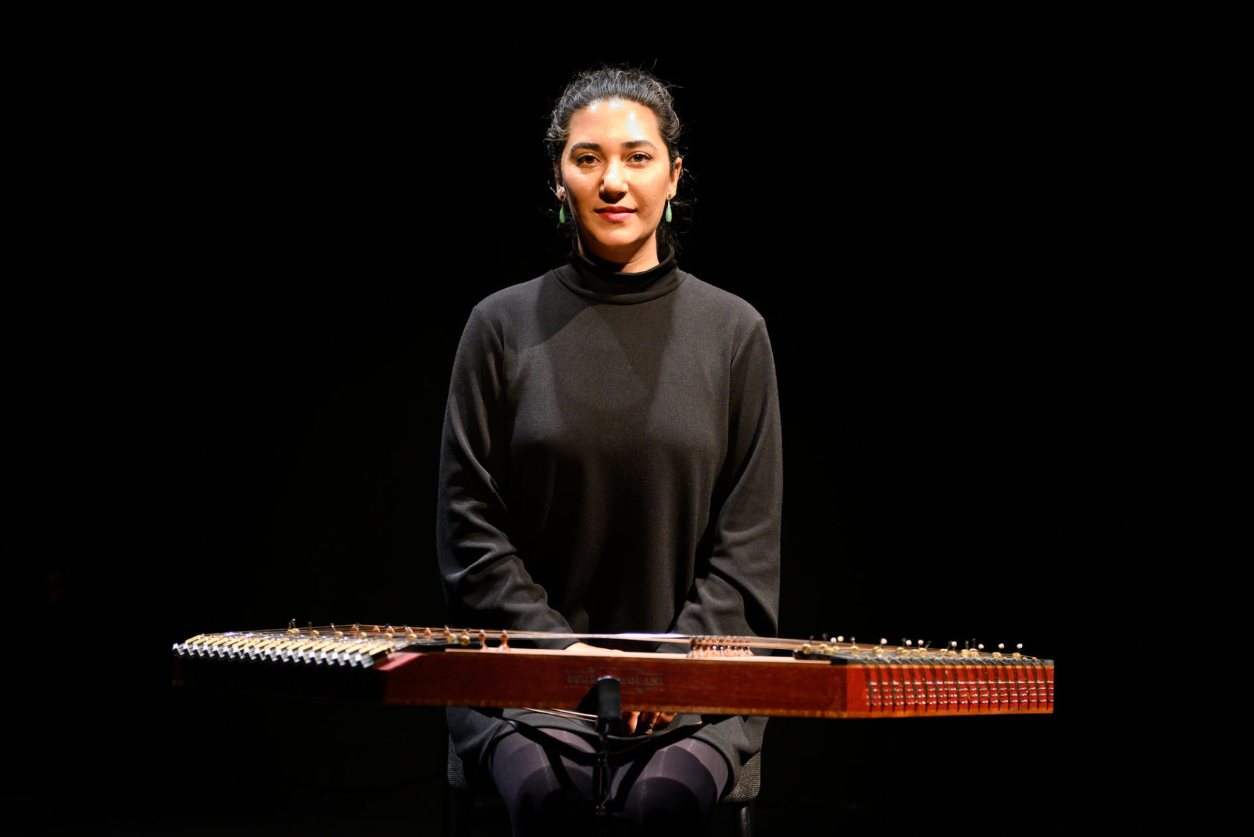 Saina Khaledi, sitting at her santour in a black outfit for As dreams are made