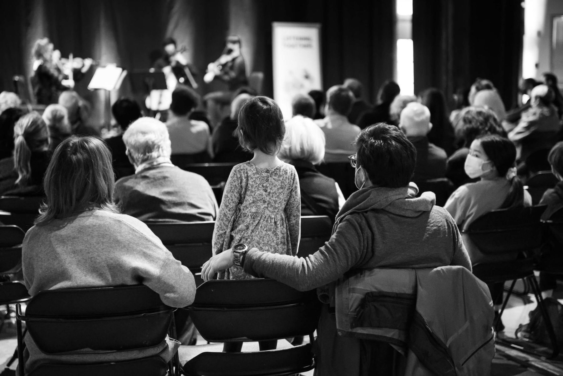 Young child and parents watch the Cedar Quarter from the audience