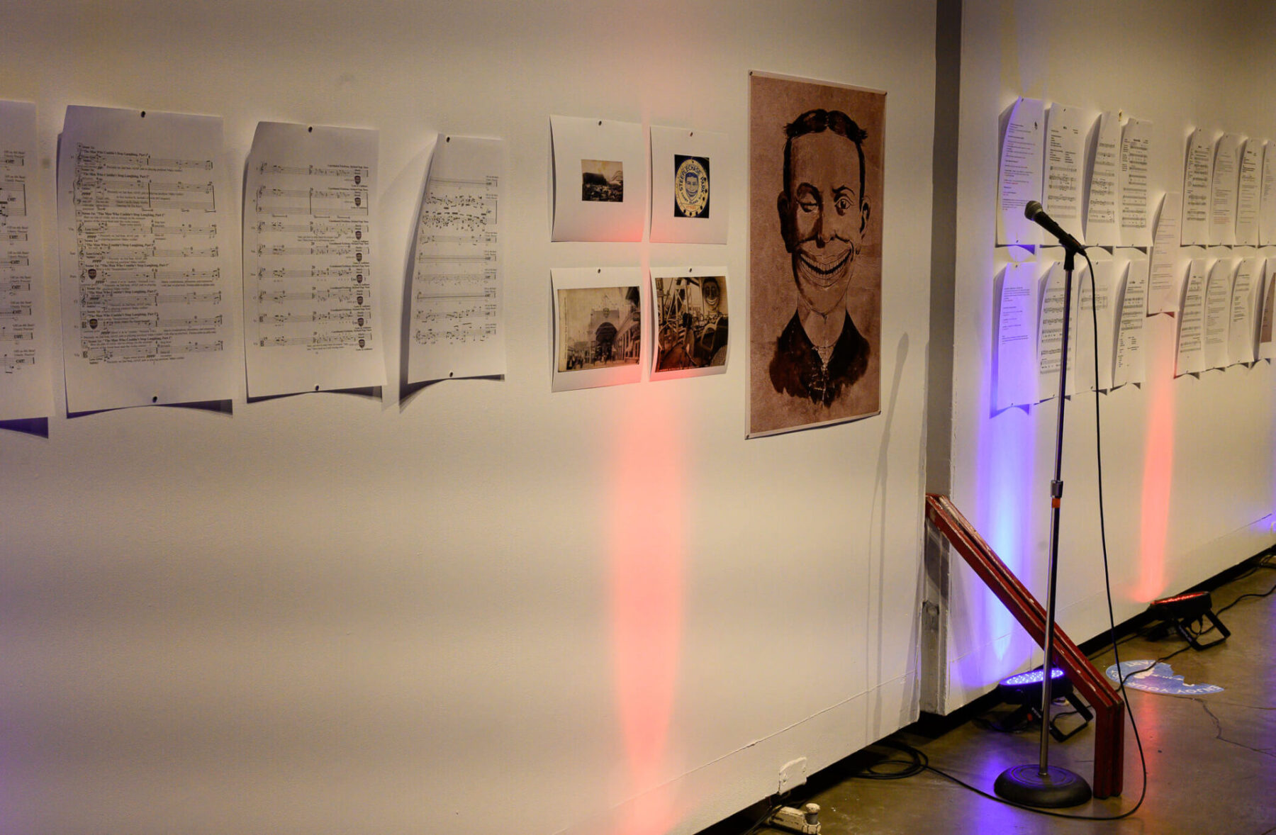 Photo of the gallery wall at the Modulus Festival with scores and images including a creepy sideshow face