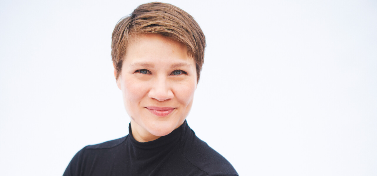 Closeup of Madeline Hildebrand, with cropped brown hair and a black turtleneck.