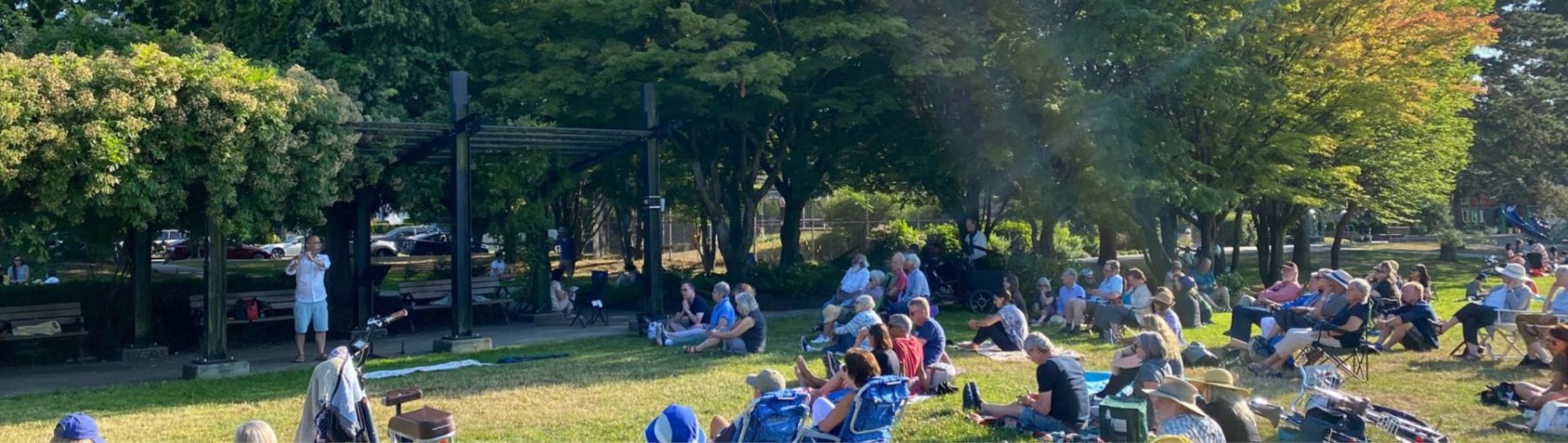 Mark Takeshi McGregor playing flute at Mount Pleasant Park in front of a live audience