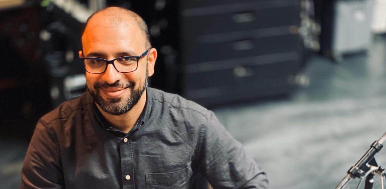 Hamin Honari in a grey shirt smiling at the camera